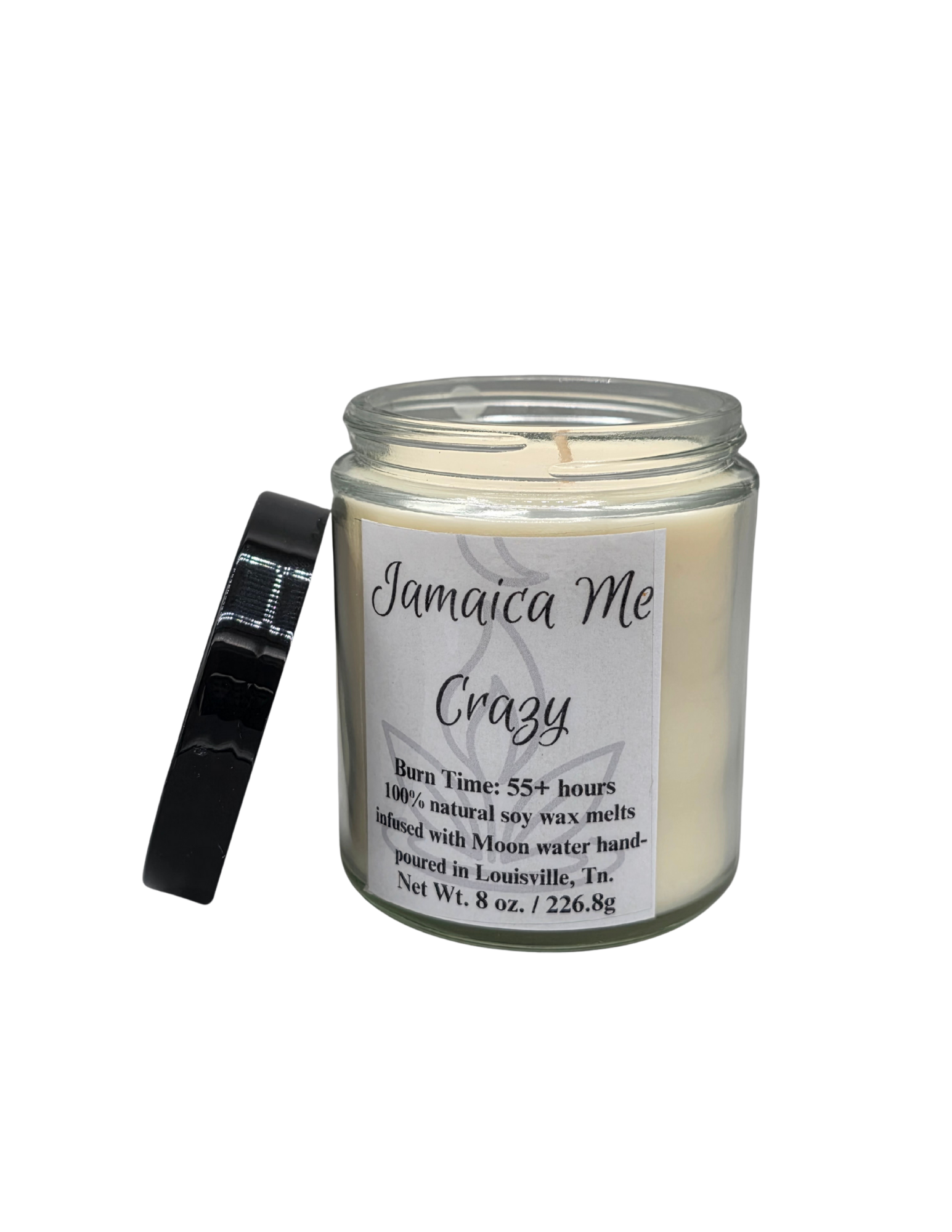 Candle in a glass jar with a black lid propped on its side and a white label with black letters that say Jamaica me crazy