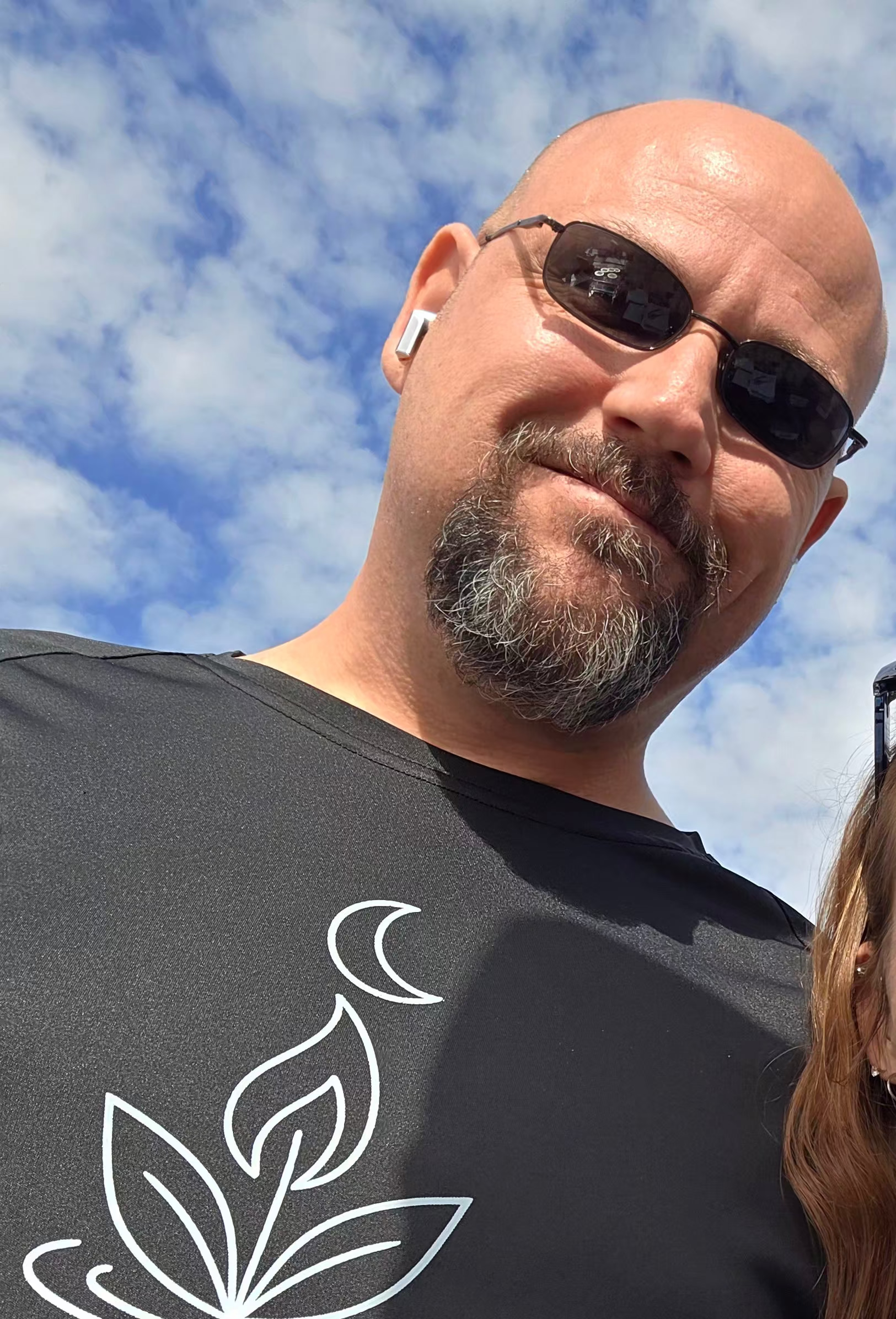 Tim wearing sun glasses and a light your way shirt at an outdoor event