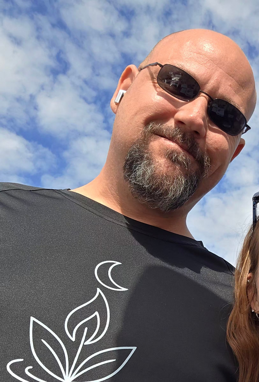 Tim wearing sun glasses and a light your way shirt at an outdoor event